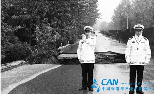 暴雨冲毁道路 三门峡交警用身躯搭起“红绿灯”