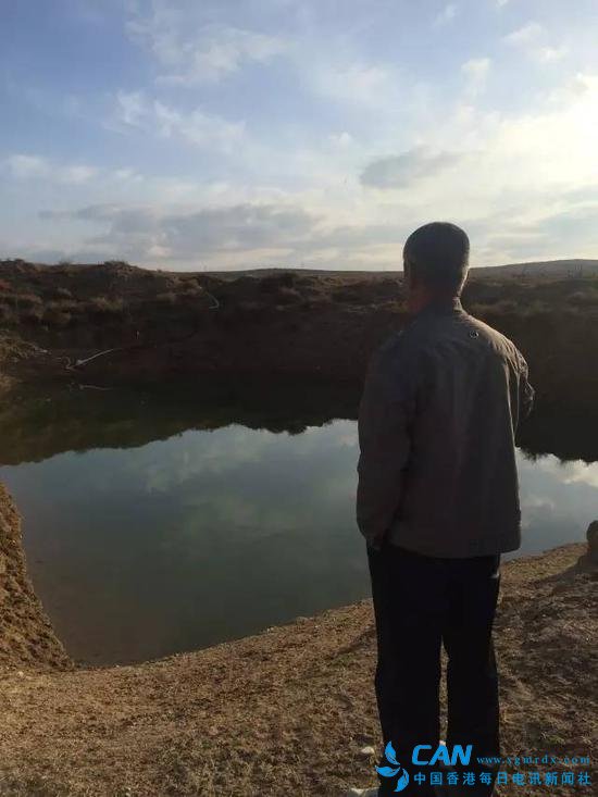 2015年10月22日，内蒙古鄂尔多斯市中和西镇蓿亥图牧业村，牧民拉外站在储水坑旁，由于附近河流已经干涸，水坑里的水也快不够用了。新华社记者吴锺昊